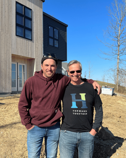 Bart Kasler and Craig Sweeney outdoors at new home construction site. 