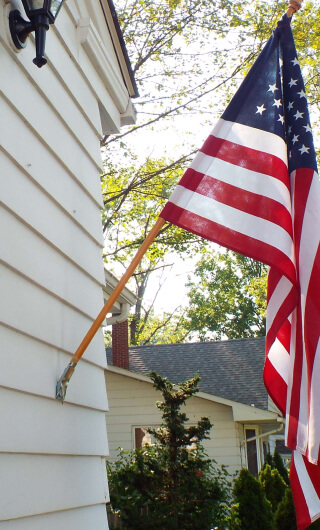 American flag hanging on a pole attached to a house