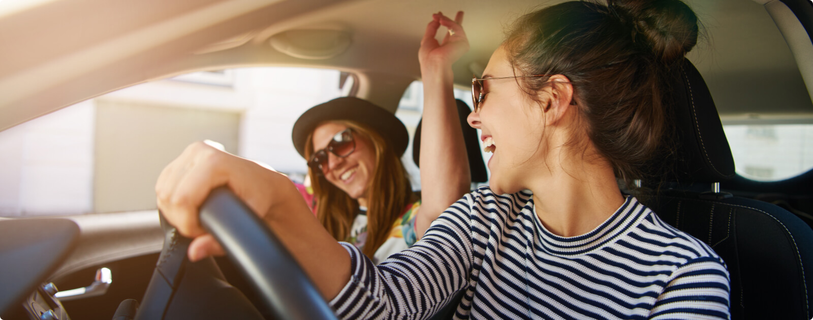 Two women happily driving in a car