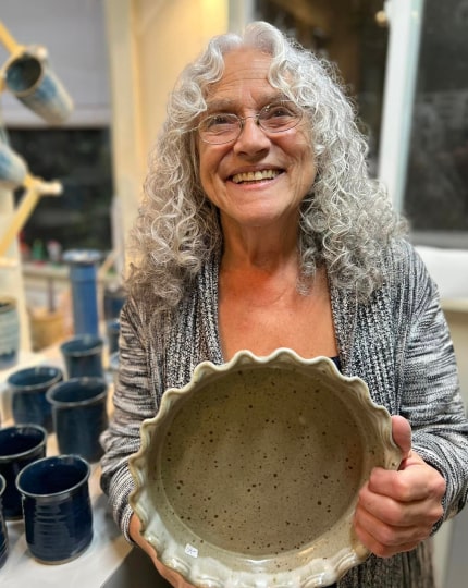 Local artist holding her pottery