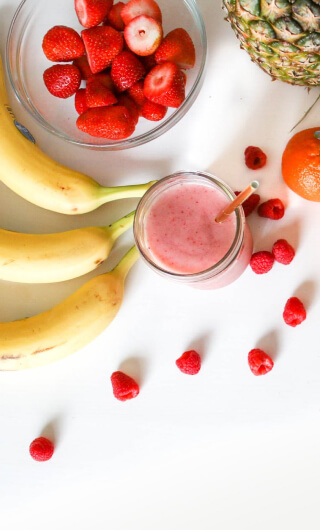 aerial view of various fruits on a table and a smoothie