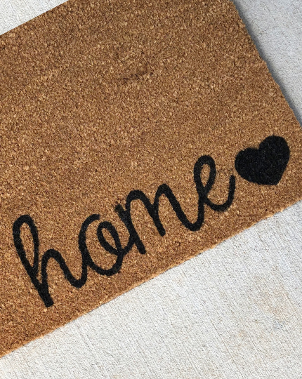 outdoor mat with the word home and heart