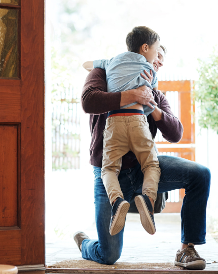 Father hugging son at the door