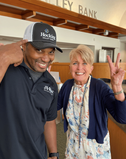 President & CEO Tammy Bobo with Aaron Thomas who is wearing a bank branded hat