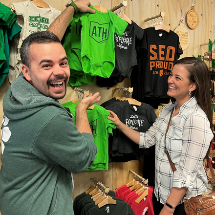 Tim Martin showing off a baby onesie at his store, Ohio is Home. 